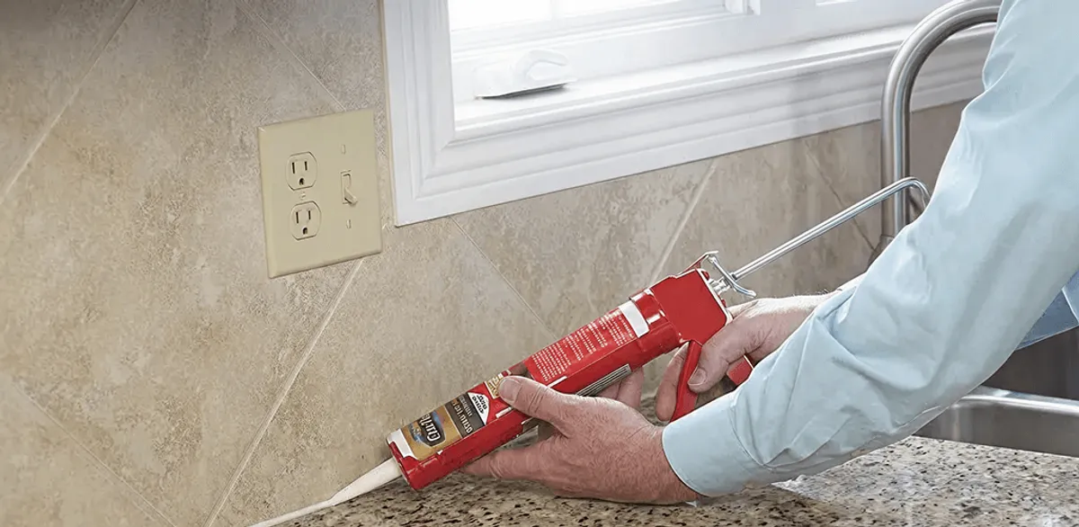 Handyman applying caulk along a kitchen backsplash and countertop seam in San Jose, CA